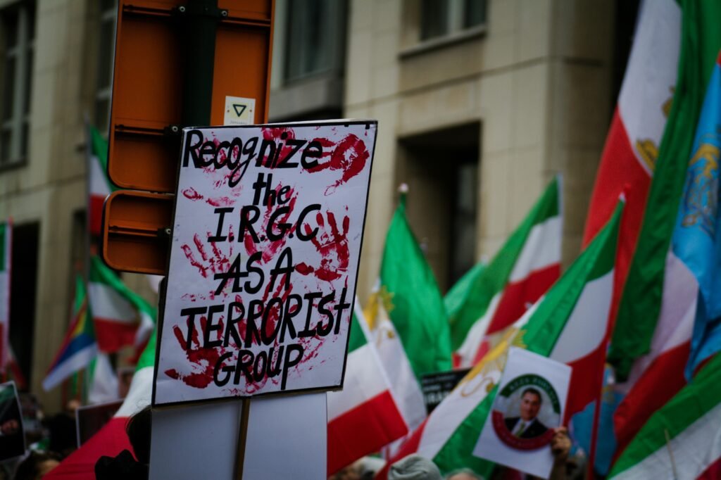 Protest in Brussels with flags and signs demanding IRGC recognition as a terrorist group.
